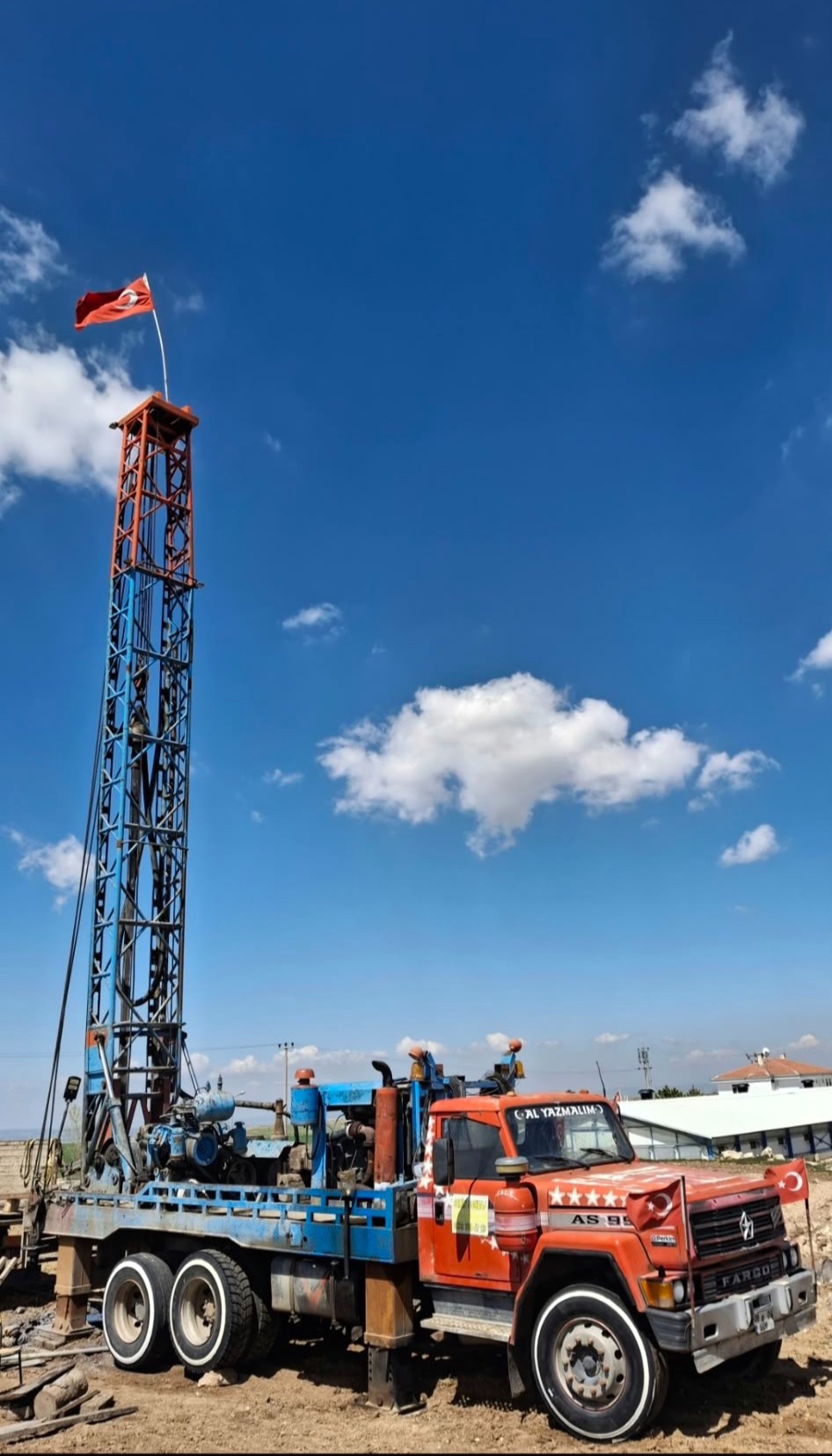 Turuncu Fargo kamyon üzerinde mavi sondaj makinesi, tepesinde Türk bayrağı
